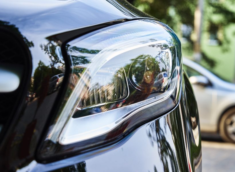 Headlight with halogen lamp on modern black car, close up